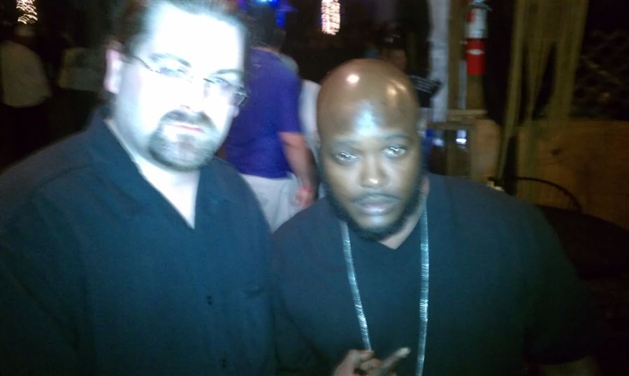 Blurry camcorder-style photo of DJ Wrekk with a friend at a club at night.